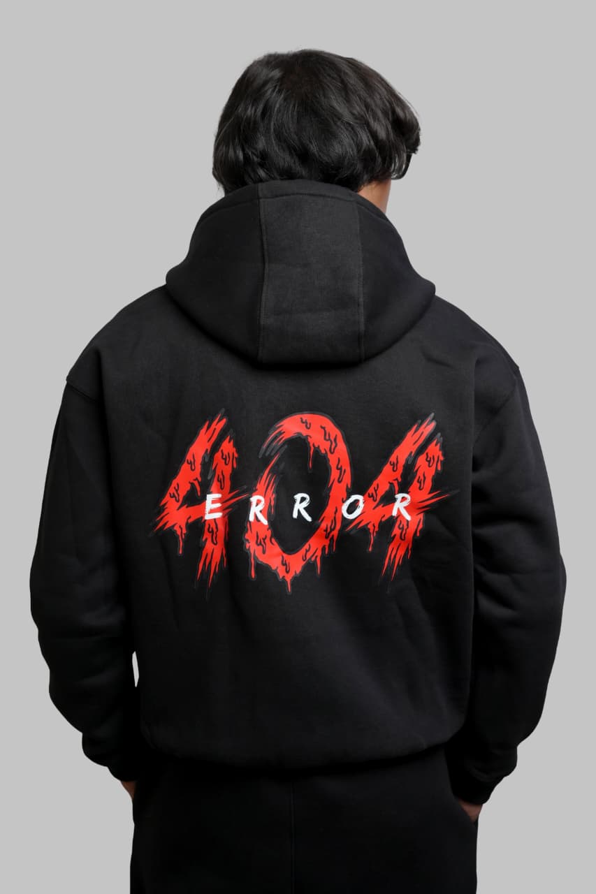 Person wearing a black hoodie with '404 Error' printed on the back against a gray background